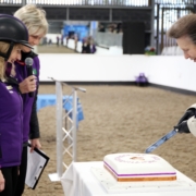 The Princess Royal cuts a cake, watched by Sheila Saner and Eleanor Dixon