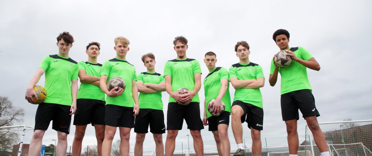 A group of Reaseheath Men’s 1st Team football players in their team kit, standing together on the training pitch ahead of the Cheshire County Cup Final.