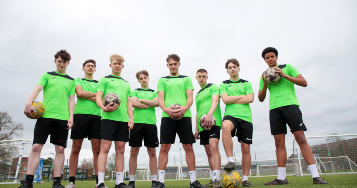 A group of Reaseheath Men’s 1st Team football players in their team kit, standing together on the training pitch ahead of the Cheshire County Cup Final.
